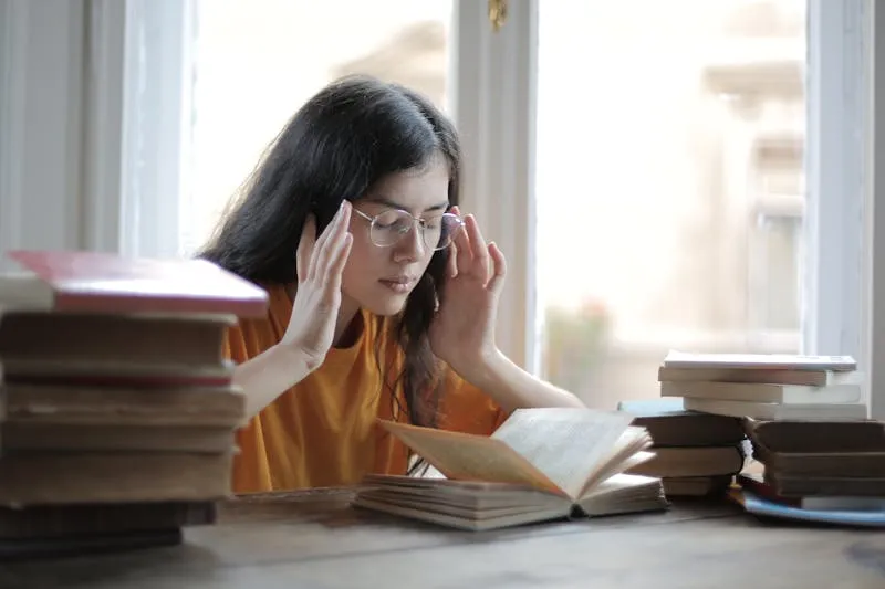 Tired woman holding her head in front of a laptop