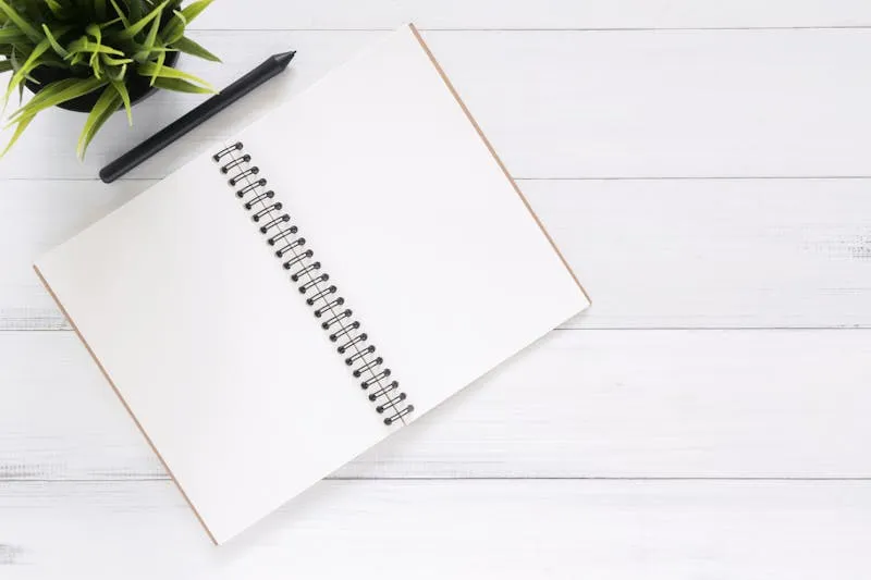 Open notebook next to an oracle deck with a pen resting on top