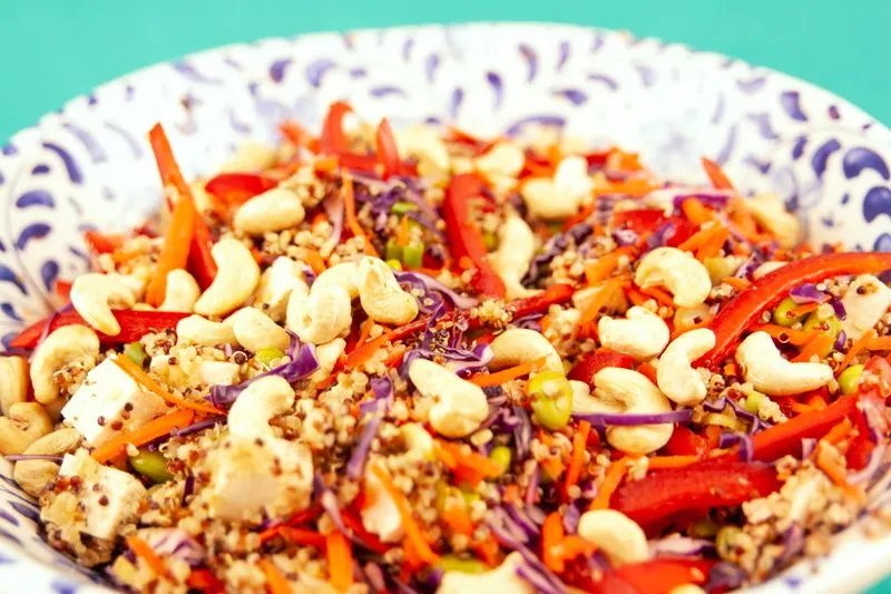 Colourful quinoa bowl with red cabbage, red pepper, carrots and cashews