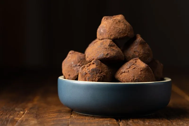 Cacao energy balls coated in cocoa powder, in a bowl