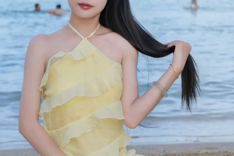 Butter yellow ruffled dress, worn by the water