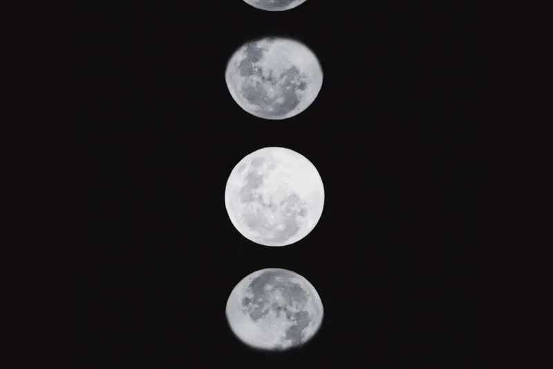 A sequence of moon phases against a night sky