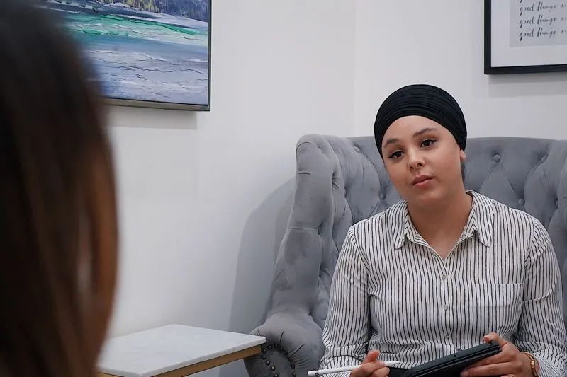 Therapy session: a practitioner listens to her client, tablet and stylus in hand