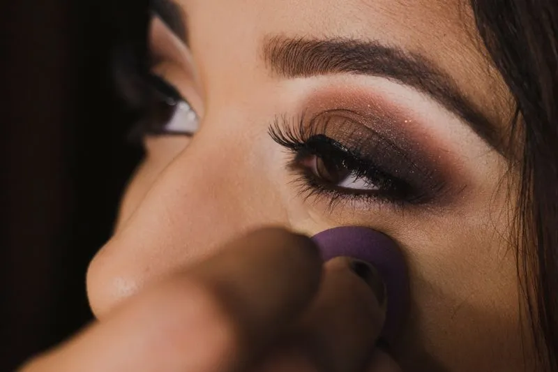 Bronze smoky eye, a make-up sponge swept under the eye to clean up fallen shadow