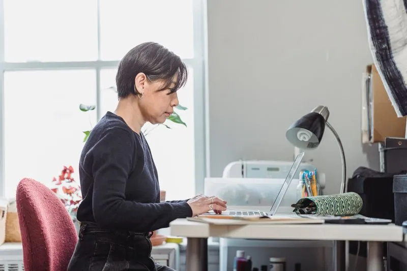 Woman sitting at her desk searching on a laptop