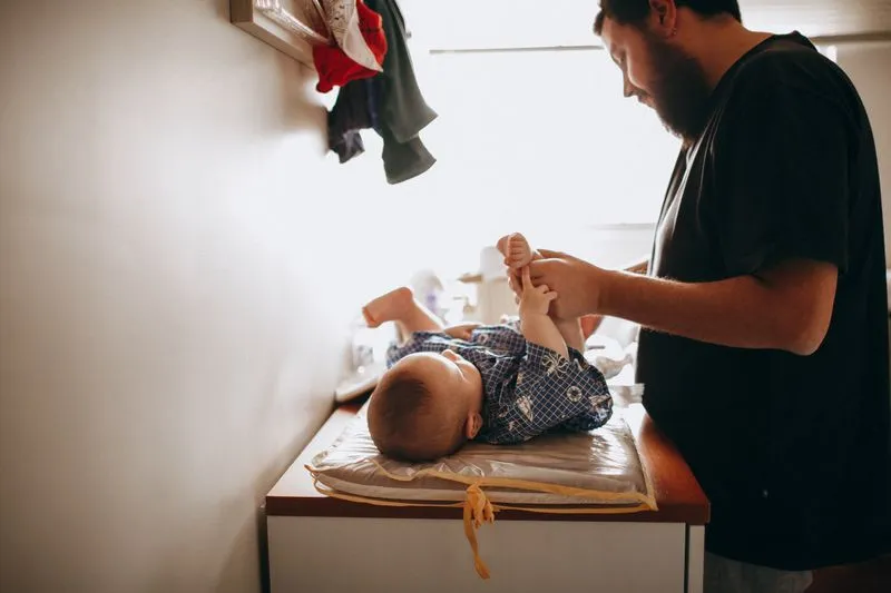 Father changing his baby's nappy on a changing table