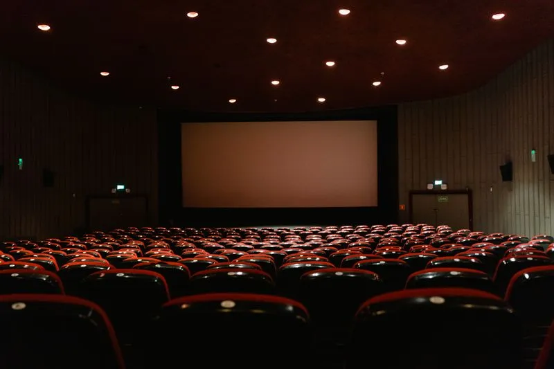 Empty cinema with glowing screen in golden light