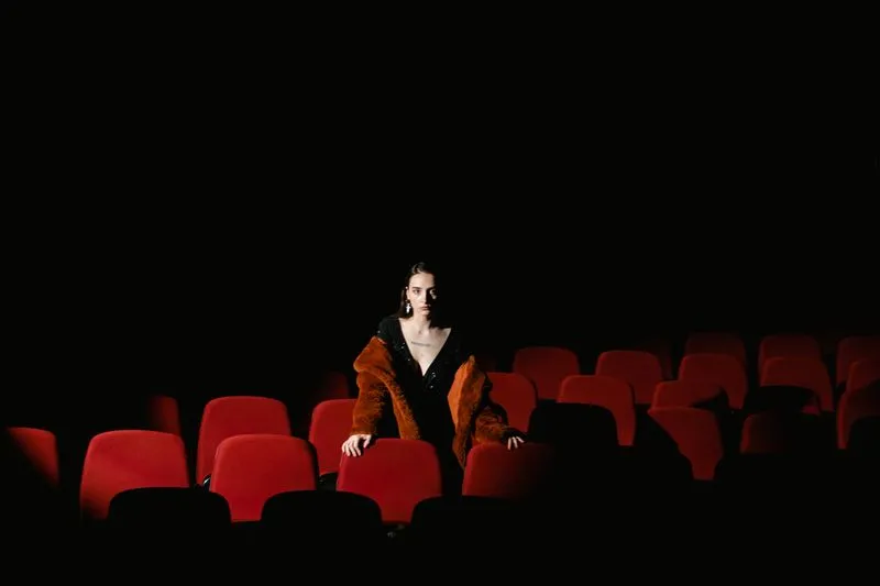 Female viewer sitting alone in a darkened cinema