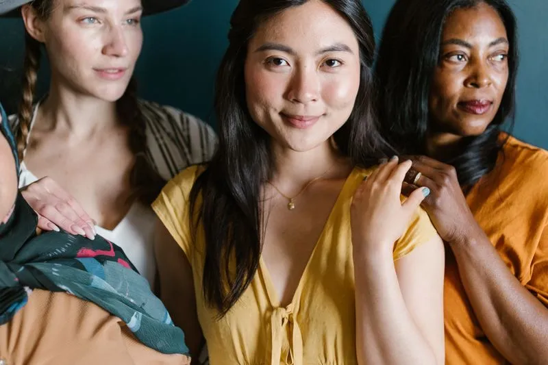 Women of different backgrounds standing close together, a hand resting on a neighbour's shoulder