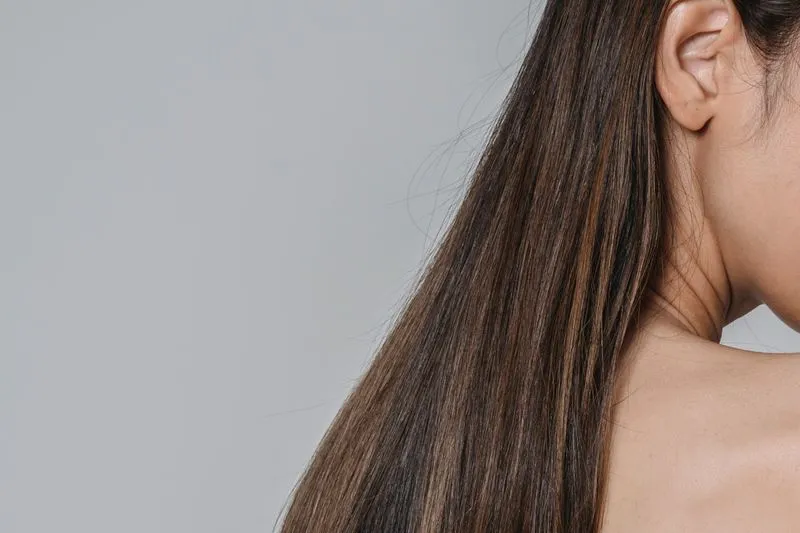 Long, smooth brown hair falling over a bare shoulder