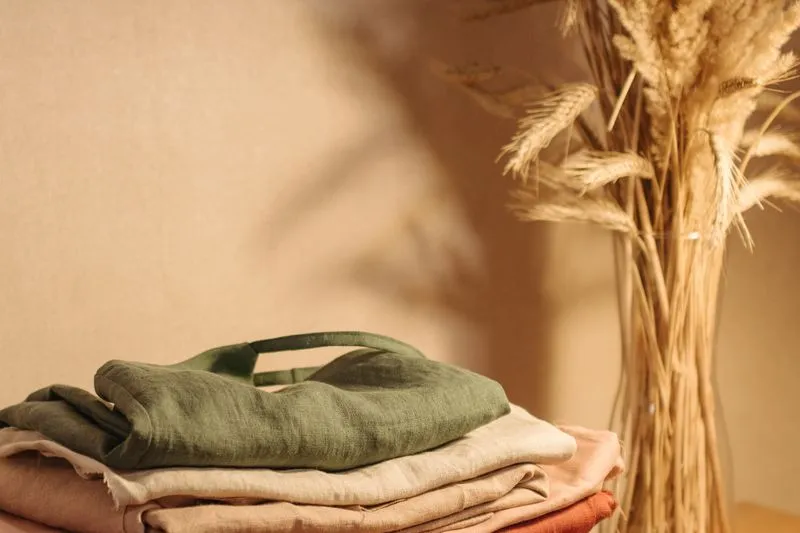 Stack of folded clothes in neutral, khaki and blush tones