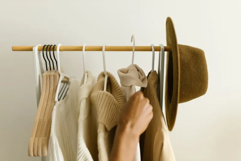 Jumpers, cardigan and hat in coordinated neutral tones on a rail