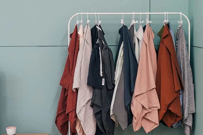 Clothes in various colours hanging on a rail