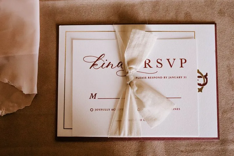 RSVP card tied with a ribbon, printed with a reply deadline of January 31