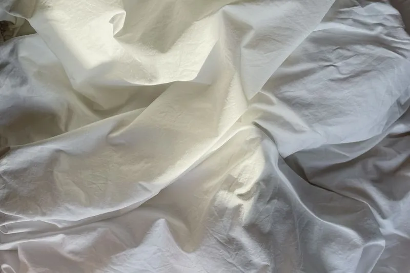 Crumpled white sheets in soft light