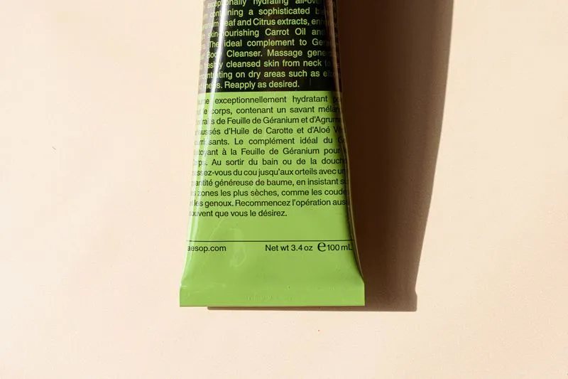 Back of a green skincare tube covered in small print in English and French, with the 100ml contents at the bottom
