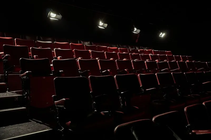 Rows of empty red tiered seats lit by four overhead spotlights