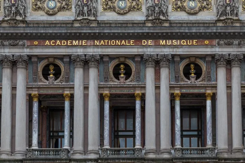 Detail of the Palais Garnier façade: marble columns, gilded busts and the inscription Académie Nationale de Musique
