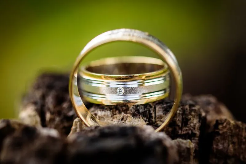 Two two-tone wedding bands, one set inside the other, with yellow gold running alongside silver