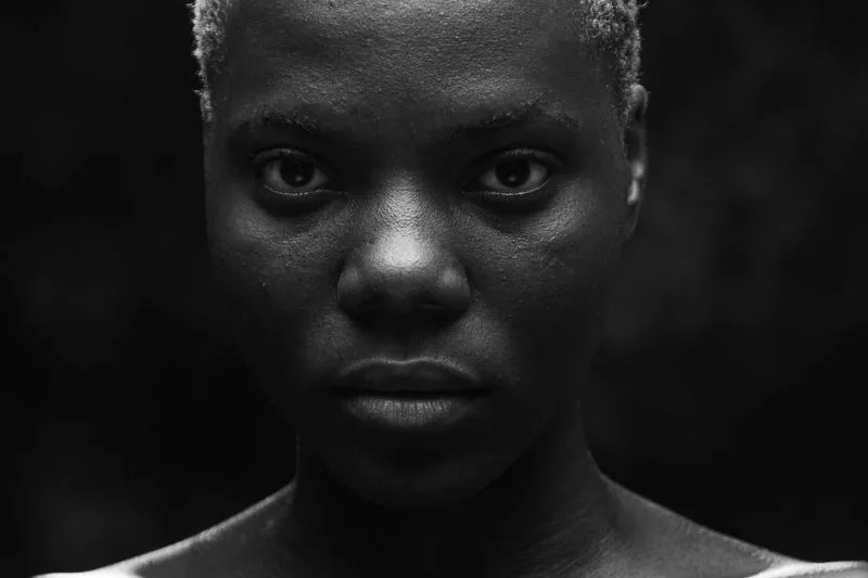 Close-up black-and-white portrait of a young Black woman with short bleached hair