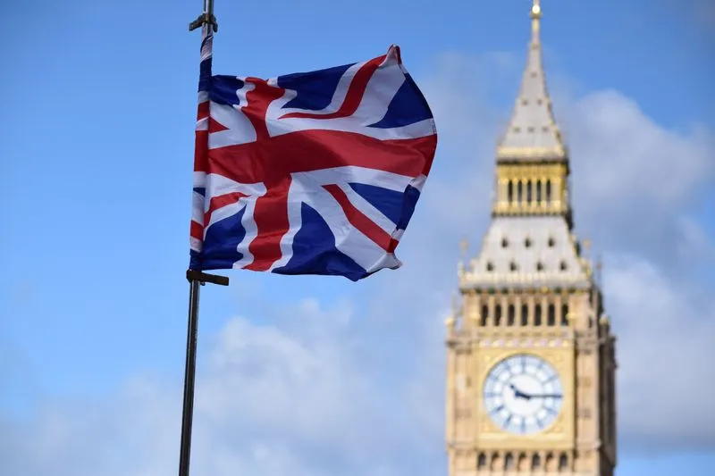 A Union Jack flag flies in front of the Elizabeth Tower, in London