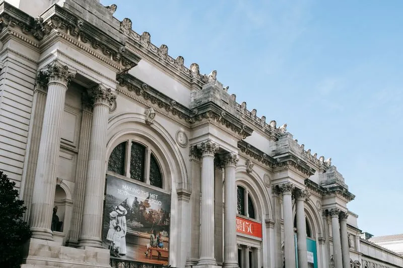Façade of the Metropolitan Museum of Art with Corinthian columns, under a blue sky