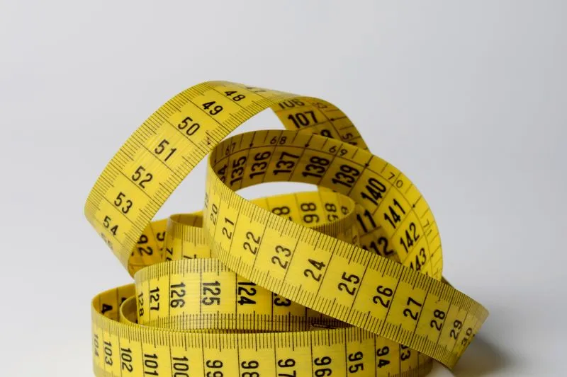 Coiled yellow sewing tape measure with the centimetre markings clearly visible