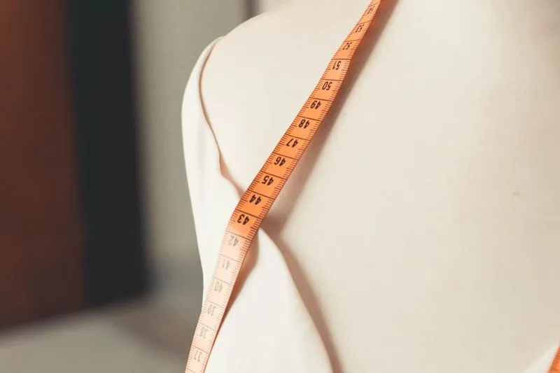 A tape measure draped over the shoulder of a dressmaker's mannequin