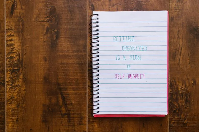 Open spiral notebook with a handwritten line on the page, resting on a wooden table