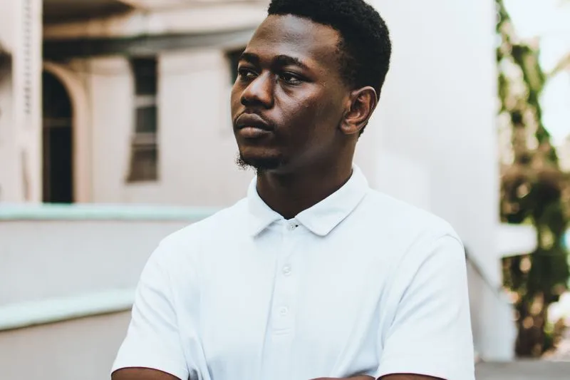 Man wearing a white polo shirt with a ribbed knit collar and button placket