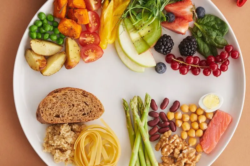 A plate of legumes, walnuts, salmon and mixed fruit and vegetables