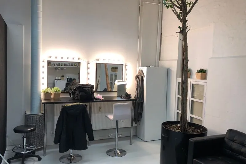 Make-up room with two mirrors framed by light bulbs and a dressing table