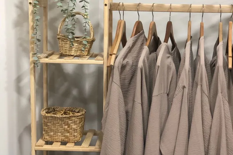 Clothes rail loaded with neutral-coloured shirts and jackets on hangers