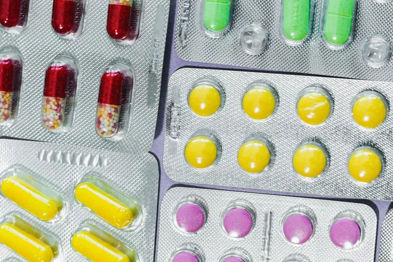Several blister packs of tablets and capsules in different colours