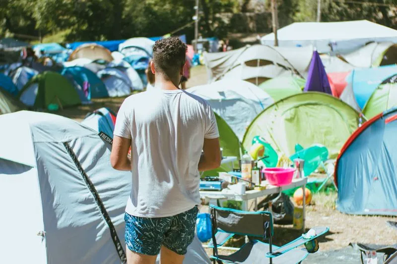 Colourful tents packed close together in broad daylight at a festival campsite