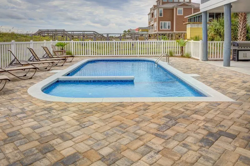 Private pool with a terrace and loungers, a white garden fence in the distance