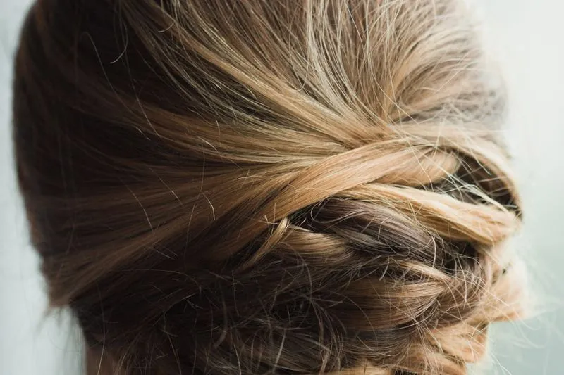 Close-up from behind of highlighted blonde hair, twisted and tucked in at the back of the head