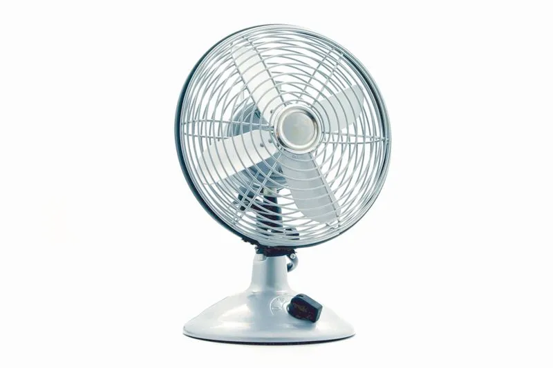 Metal desk fan photographed front-on against a white background