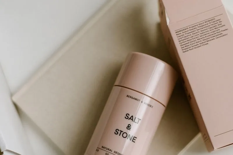 Pink natural deodorant tube resting on its packaging box