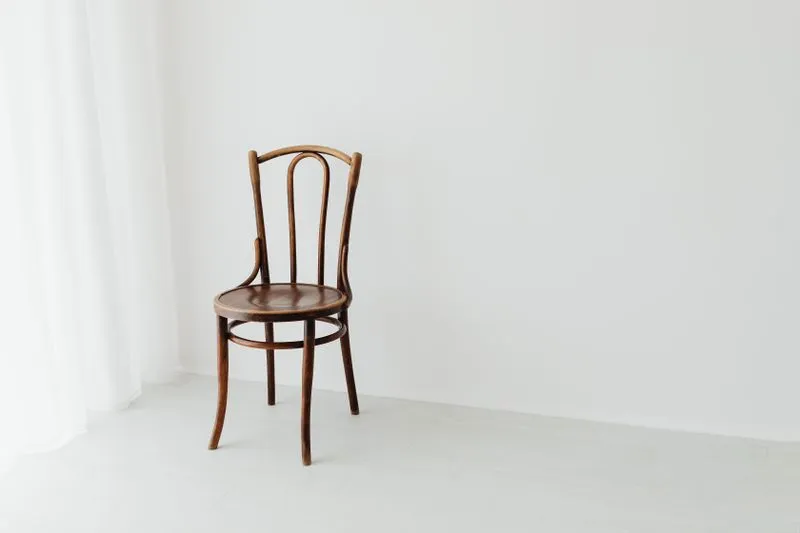 Wooden chair without armrests in a bright room with white walls