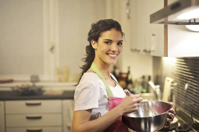 Smiling woman in kitchen wearing an apron