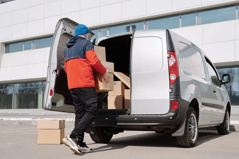 A man loading boxes into a small van
