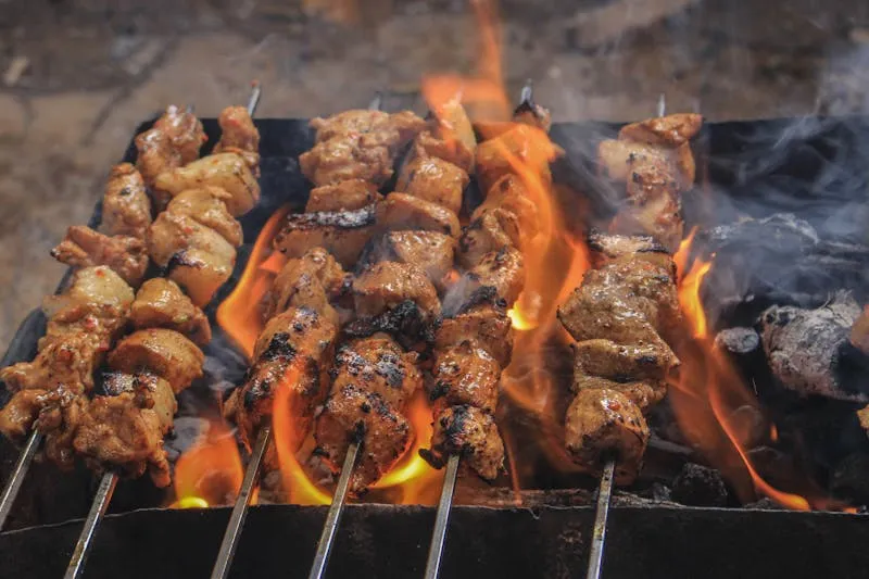 Kofta and marinated chicken skewers on a charcoal grill